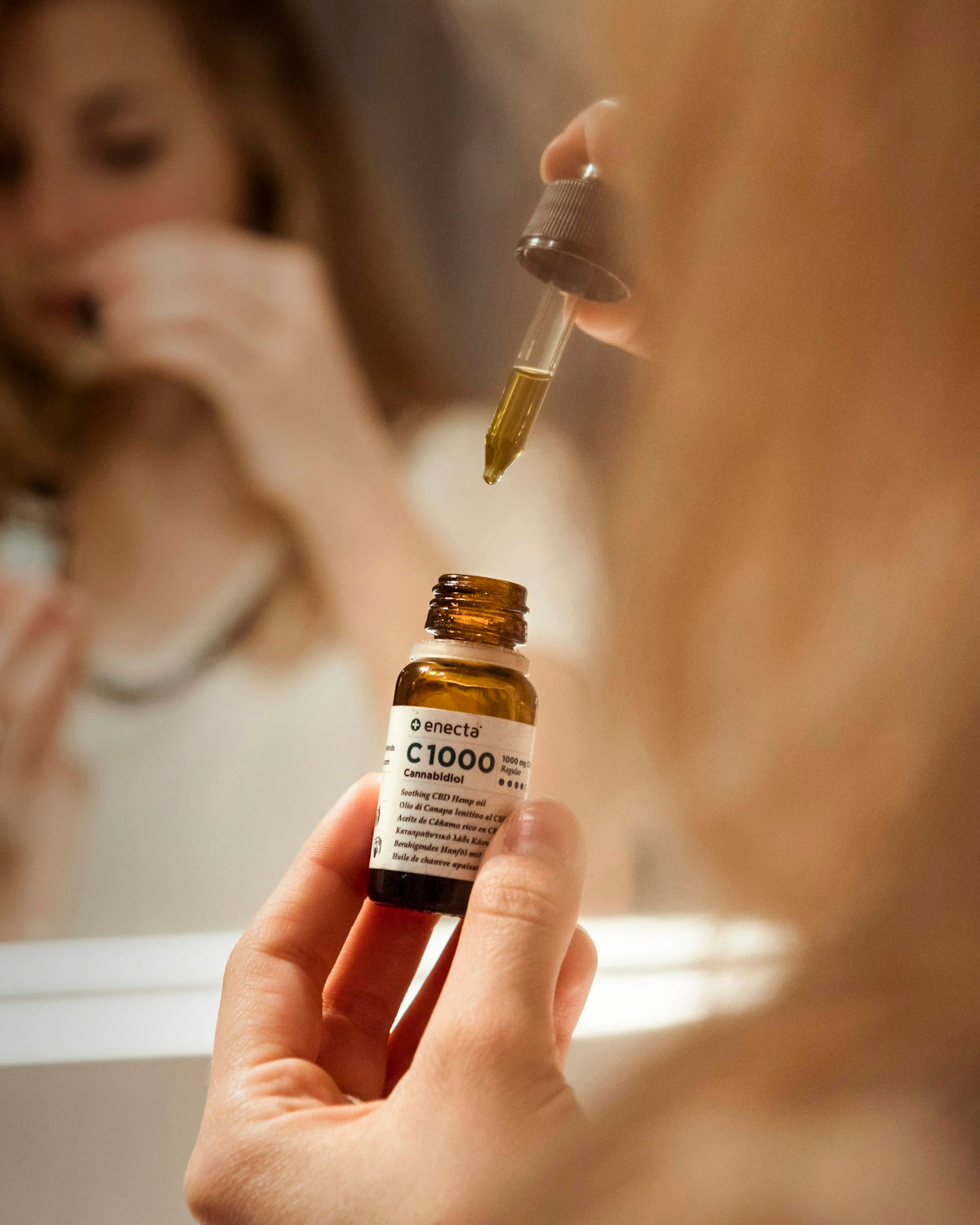 selective focus photography of person holding C1000 bottle