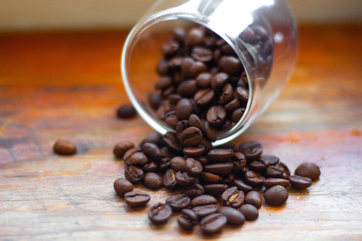 a pile of coffee beans spilling out of a cup