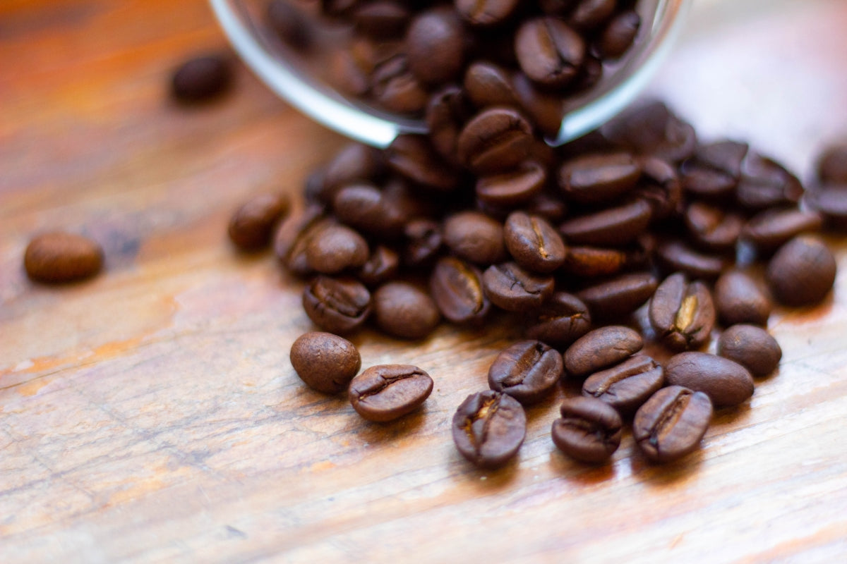 a pile of coffee beans sitting on top of a wooden table